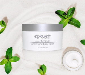 Epicuren Discovery Mint Renewal Body Polish in a jar surrounded by mint leaves and sand, showcasing a refreshing body care product.