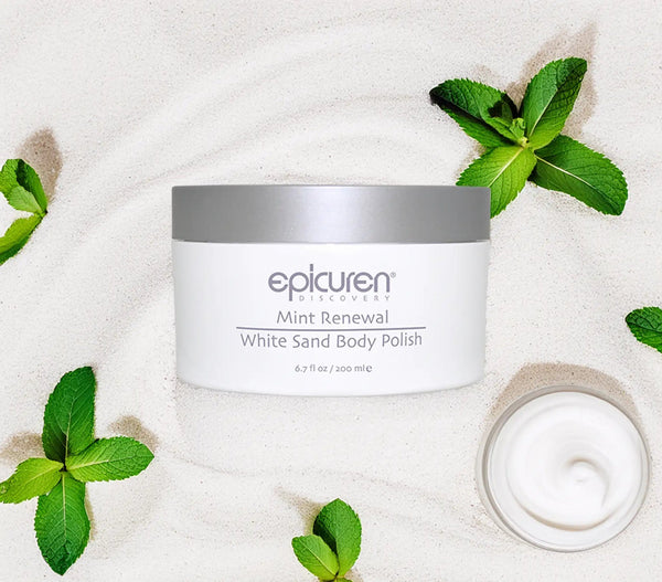 Epicuren Discovery Mint Renewal Body Polish in a jar surrounded by mint leaves and sand, showcasing a refreshing body care product.