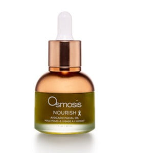 Osmosis Nourish Avocado Facial Oil bottle with green cap on a wooden surface, showcasing its natural moisturizing properties.