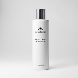 Le Mieux Oh My Glow Activator toner in an 8oz bottle with clear liquid and a white cap, displayed against a plain background.