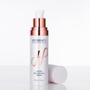 Hydrinity Vivid Brightening Serum in a clear bottle with cap off, showcasing the vibrant serum inside.