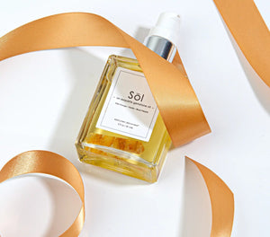 Epicuren Discovery Sol Exquisite Gemstone Oil in a 2oz bottle, surrounded by natural elements for aromatherapy.