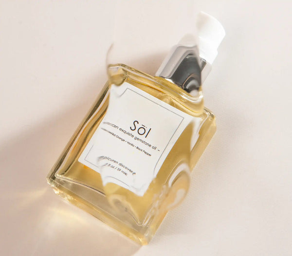 Epicuren Discovery Sol Exquisite Gemstone Oil in a 2oz bottle, surrounded by natural elements for aromatherapy use.
