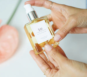 Epicuren Discovery Sol Exquisite Gemstone Oil 2oz in a serene aromatherapy setting with elegant bottle and warm lighting.