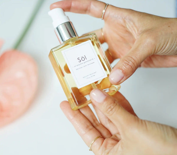 Epicuren Discovery Sol Exquisite Gemstone Oil 2oz in a serene aromatherapy setting with elegant bottle and warm lighting.